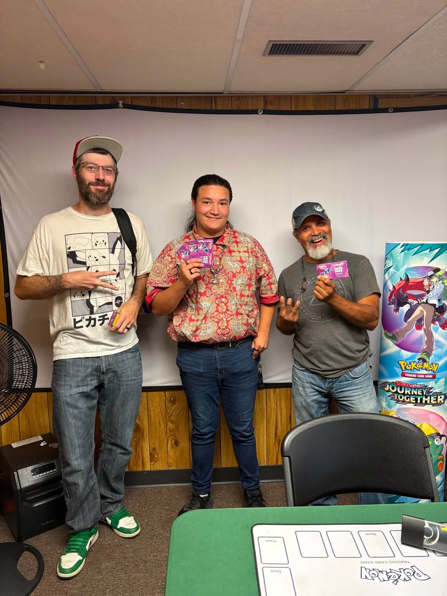 Local players posing with cards at the shop